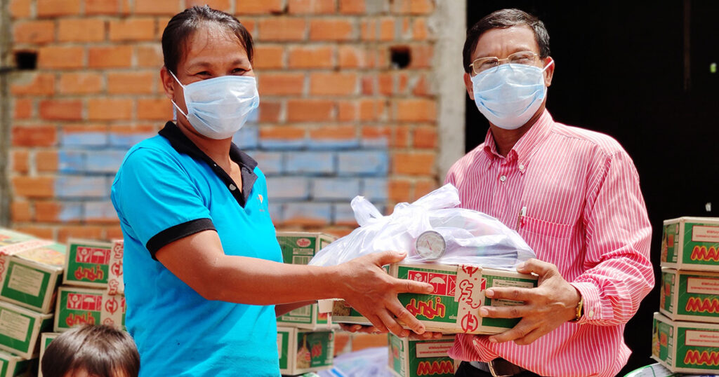 Local pastor Mao Saron distributes at his house church in Thbom Khmum_a