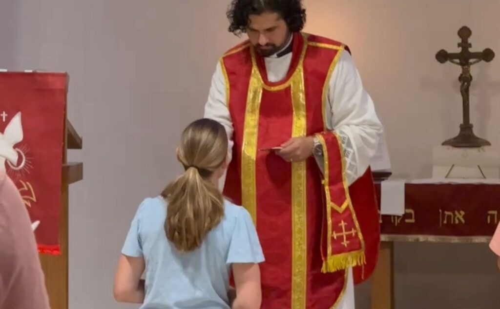 Rev. Sahar Sadlovsky providing the Lord's Body and Blood to his wife Maria